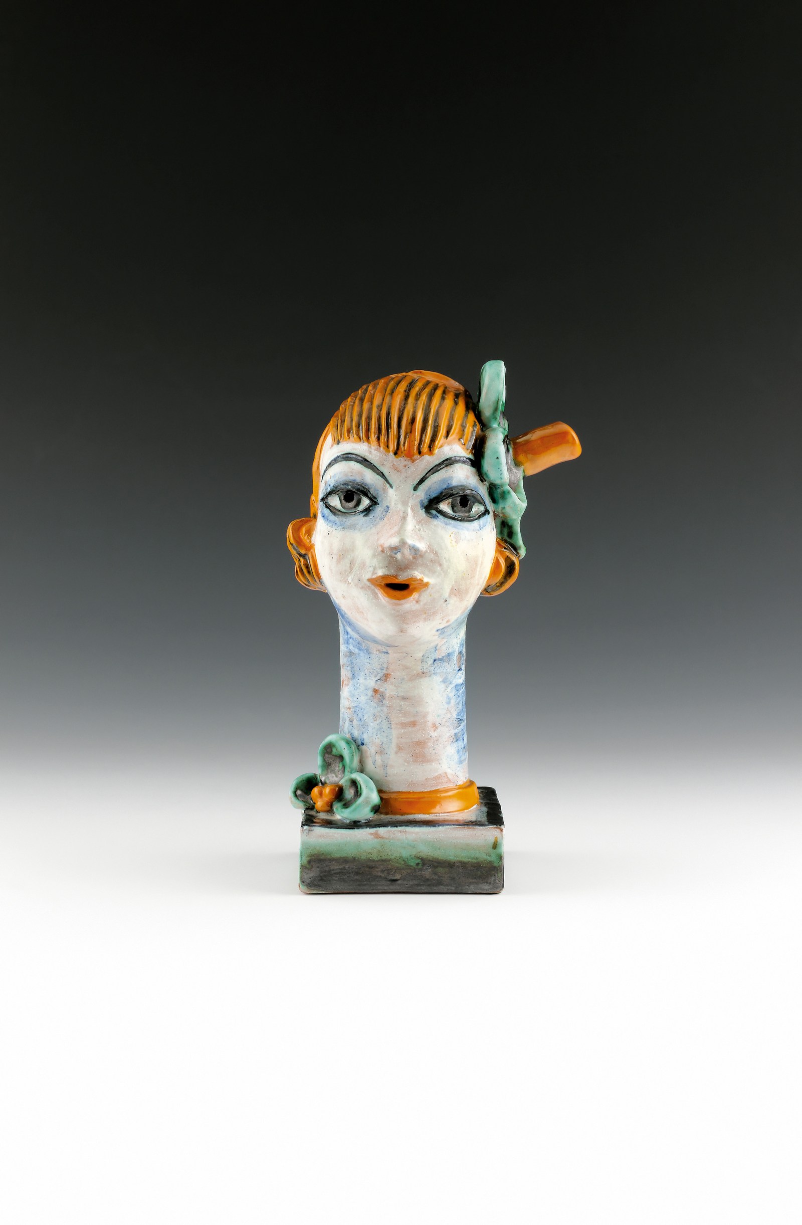 Vally Wieselthier, “Head of a Woman, Model 511,” a glazed ceramic head with red bobbed hair, blue eyes and a green bow