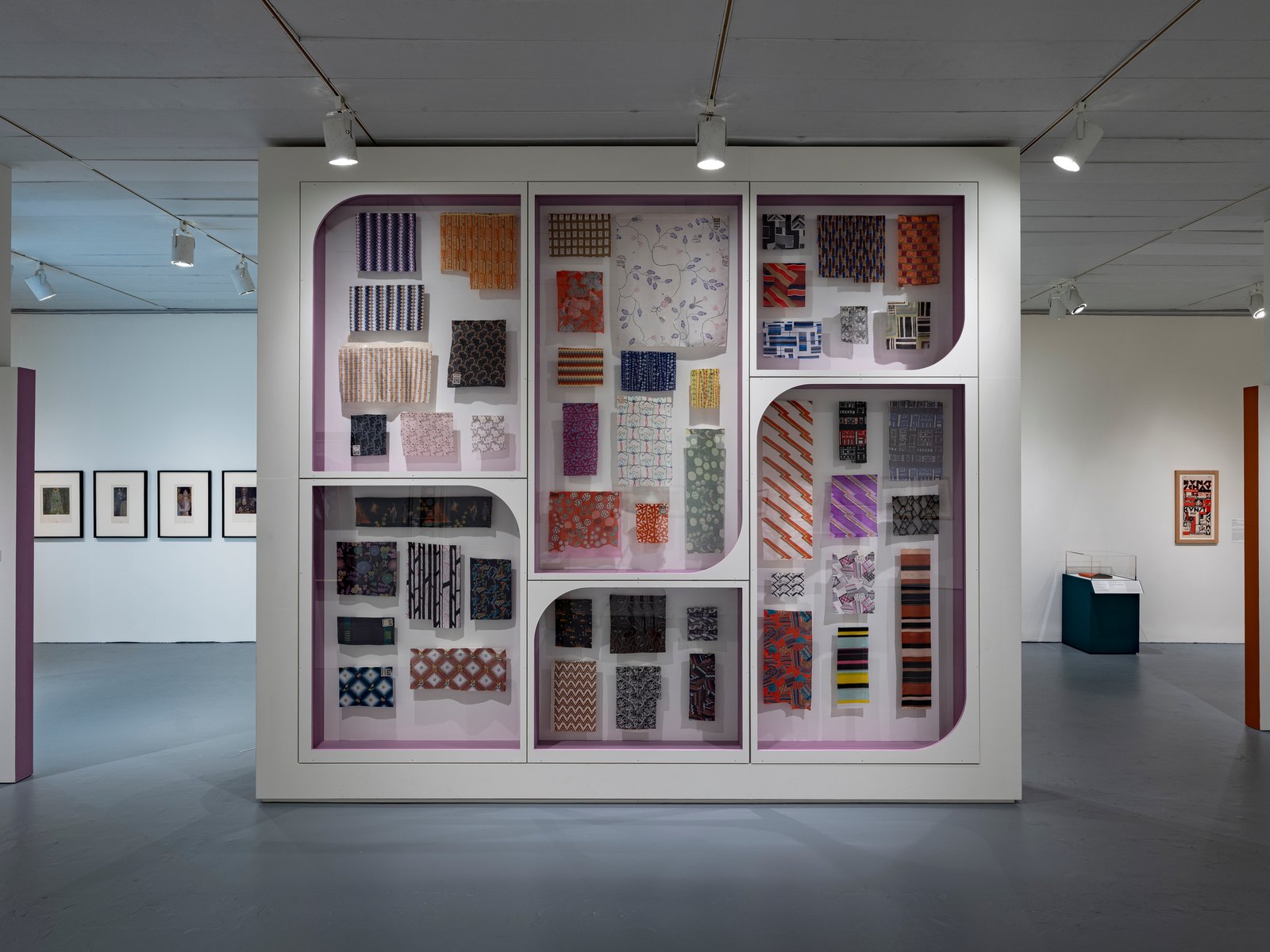 A wall of Wiener Werkstätte textile samples in bright patterns in “Modernity and Opulence” at the Jewish Museum